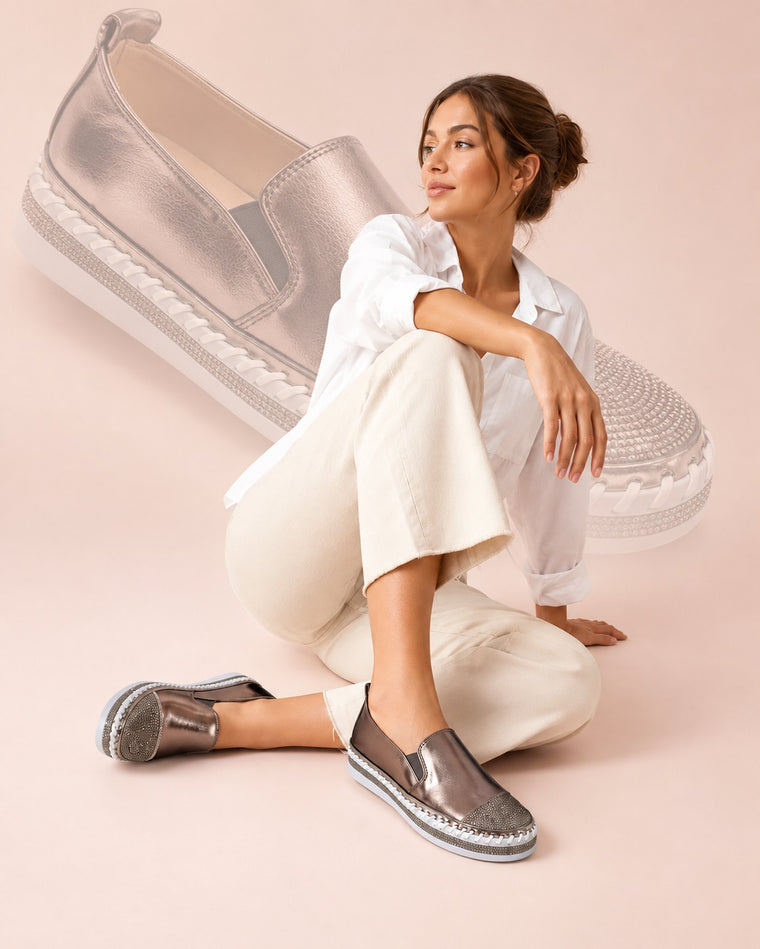 Model seated wearing the VIANY.DIXON Crystal Slip-On in bronze
