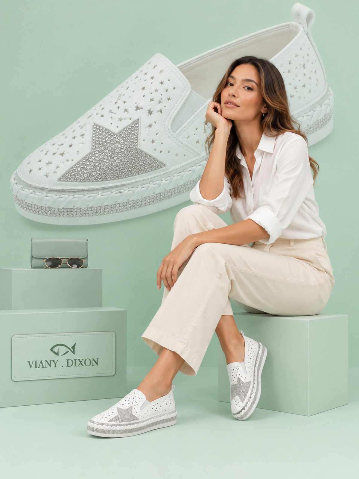 Model seated wearing the VIANY.DIXON Perforated Slip-On in white
